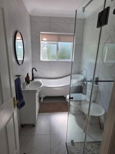 a bathroom with a tub and a sink and a toilet at Jonker's Cottage in Malgas