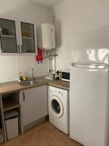 a kitchen with a white refrigerator and a washing machine at Clau al castell apartament in Serra