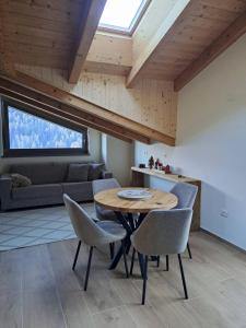 a living room with a wooden table and chairs at Alpen Lodge Premium Apartment in Mezzana