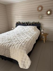 a bedroom with a bed with a white comforter at Casa Rosa - Sfeervolle cottage met jacuzzi in Erm
