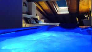 a room with a bed and a large blue tub at Apartamentos La Alborada Medieval in Ayllón