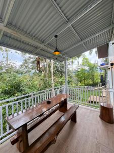 a wooden bench sitting on the porch of a house at De Cabin Situjuah in Situjuhbatul