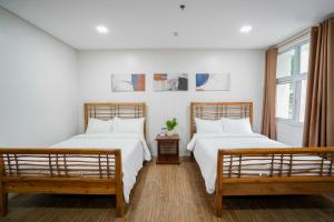 two beds in a room with white walls at Vine and Canopy in Olongapo +241 photos