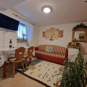 a living room with a couch and a table at Appartamento Genzianella Monolocale in Cavalese