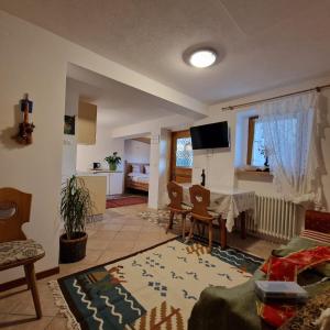 a living room with a table and a dining room at Appartamento Genzianella Monolocale in Cavalese