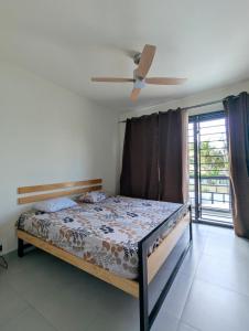 a bedroom with a bed and a ceiling fan at Jabali in Roches Noires +6 photos
