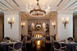 a room with tables and chairs and a chandelier at The Jefferson Hotel in Washington, D.C.