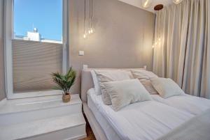 a bedroom with a white bed and a window at HelApart - Casa Baia in Hel
