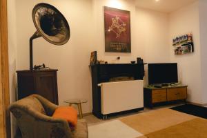 a living room with a chair and a television at Lyves in Liège