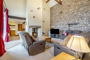 a living room with couches and a stone wall at 3 Bed in Ingleton oc-l34471 in Ingleton