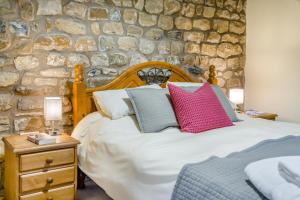 a bedroom with a bed and a stone wall at 3 Bed in Ingleton oc-l34471 in Ingleton