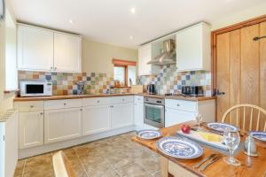 a kitchen with white cabinets and a wooden table at 2 Bed in Ingleton oc-h34470 in Ingleton +13 photos