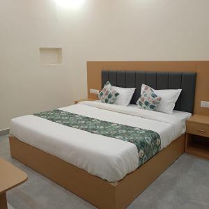 a bedroom with a large bed with two pillows at HOTEL SHIVAAY near by urban Square mall and nexus celebration mall in Bedla
