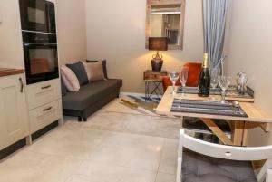 a living room with a couch and a table with wine glasses at 1885 The Retreat in Matlock