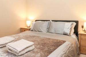 a bedroom with a bed with towels on it at 1885 The Retreat in Matlock