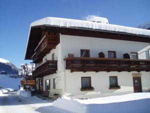 a building with snow on the side of it at Frühstückspension TROGER in Sankt Jakob in Defereggen