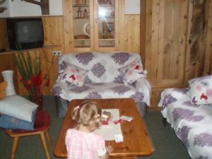 a little girl in a living room with a coffee table at Frühstückspension TROGER in Sankt Jakob in Defereggen