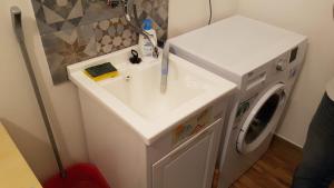 a bathroom with a sink and a washing machine at Downtown Living in Catania