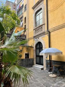 an umbrella and a table in front of a building at Downtown Living in Catania