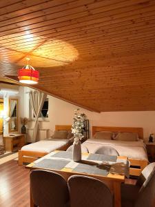 a bedroom with two beds and a table with chairs at Studio Apartment Žafran in Smoljanac