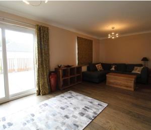 a living room with a couch and a large window at Grandholm Crescent in Aberdeen