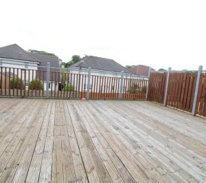 a wooden deck with a fence and some houses at Grandholm Crescent in Aberdeen