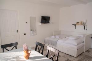 a bedroom with a bed and a table with chairs at Marelle Porta in Veresegyház