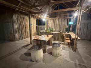 a room with a wooden table and two logs at Homey Bamboo Lanta in Ban Ai Dao