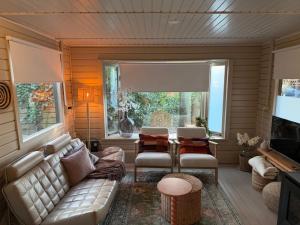 a living room with a couch and a table at Casa Rosa - Sfeervolle cottage met jacuzzi in Erm