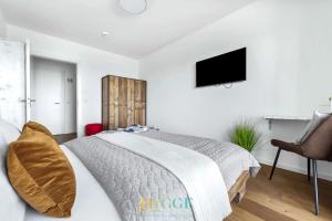 a bedroom with a bed and a tv on the wall at Lodge 18 in Olpenitz