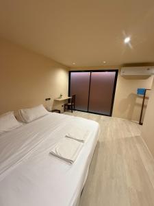 a bedroom with a large white bed and a desk at Homey Bamboo Lanta in Ban Ai Dao