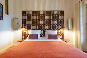 a bedroom with a large bed with a large headboard at Mas du Couvin, maison d'hôtes en Camargue in Saintes-Maries-de-la-Mer