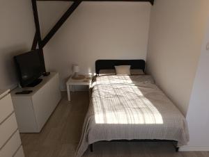 a small bedroom with a bed and a tv at Apartament Mariacka in Bydgoszcz