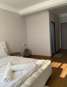 a white bed in a room with a couch at deborahhomes in Marimbeti +4 photos