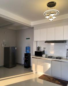 a kitchen with white cabinets and a stainless steel refrigerator at deborahhomes in Marimbeti