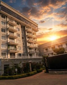 a large apartment building with the sunset in the background at deborahhomes in Marimbeti