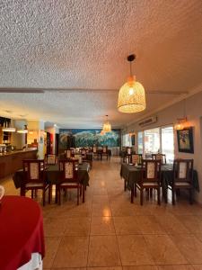 a dining room with tables and chairs and a chandelier at Le Saint Georges Hotel in Port Louis