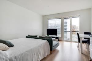 a bedroom with a bed and a desk and a television at Simple studio for two in Turku Center in Turku