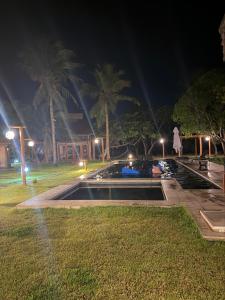 a person standing next to a swimming pool at night at casa LuMar in Atins +69 photos