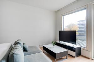 a living room with a couch and a large window at Simple studio for two in Turku Center in Turku