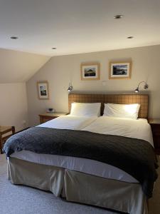 a bedroom with a large bed with two pillows at Craigruie Farmhouse in Balquhidder