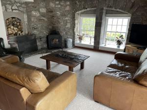 a living room with a couch and a coffee table at Craigruie Farmhouse in Balquhidder