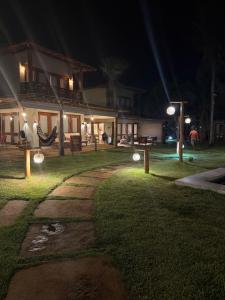 a house with lights in the yard at night at casa LuMar in Atins