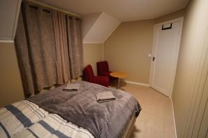 a bedroom with a bed and a table and chairs at Cherry Rooms in Tromsø