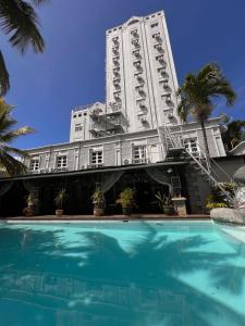 a building with a swimming pool in front of a building at Le Saint Georges Hotel in Port Louis