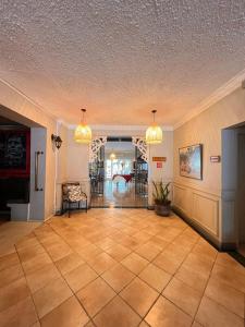 a large room with a tile floor and two chandeliers at Le Saint Georges Hotel in Port Louis