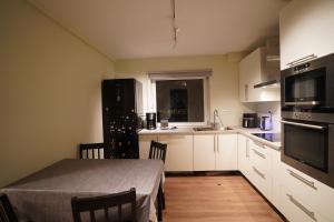 a kitchen with white cabinets and a table with a table sidx sidx sidx at Cherry Rooms in Tromsø