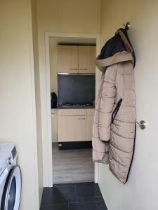 a coat hanging on a wall in a kitchen at Chalet in menaam in Dronrijp