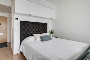 a bedroom with a large white bed with a black headboard at Simple studio for two in Turku Center in Turku +1 photo
