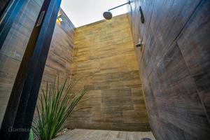 a bathroom with a wooden wall and a plant at Utopia Casas Boutique in Oaxaca City +71 photos